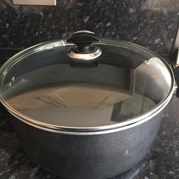 A large non-stick saucepan, with a glass lid and side handles.  Has be used and there are a few scratches on the base. Please see photos