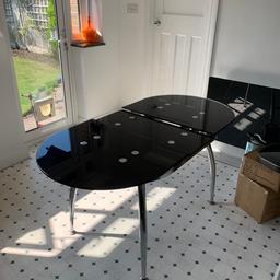 A black tempered glass dining table. Fits 6 chairs This is extendable.

Quick sale! Please see size below

Closed table size
Length = 47 1/2 inch
Width = 29 1/2 inch

Extended
Length 59 1/2 inch

The table has 1 noticeable scratch. There are other very light scratches but are not noticeable.
It might need a clean as well
I can give you all 6 chairs for £20 extra but they are not in good condition and the leather is ripped but you can upholster the chairs