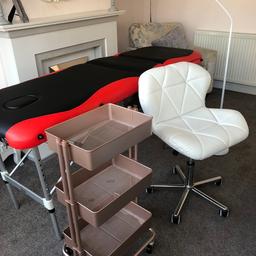 Massage table with quilted white swivel chair, double light lamp and rose gold trolley. Used for eyelash extensions.