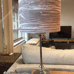 Chrome table lamp with nice crystal detailing near base. Lamp base diameter: 13cm. Lamp height approx 50cm (including shade). With lovely crushed silver shade. Lamp shade: 25cm diameter x 18cm height. Bulb included.