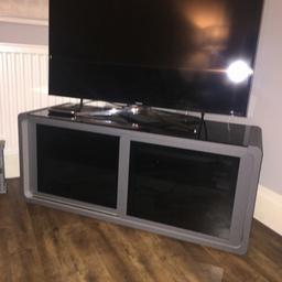 Matt grey, black glass sliding doors. and glass shelves inside and glass top. brilliant condition. I have my 55 inch TV on it with plenty of room.
