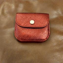 here is my radley purse in very nearly new condition. it has a flapover coin section with the word smile written on, on the back is a card and money section with a press stud fastening. it is red
