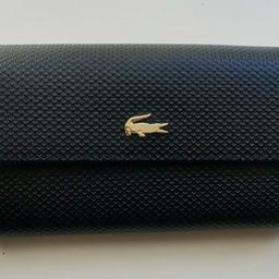 LACOSTE Women's Chantaco Bicolour Piqué Leather Wallet in black/navy
Brand new with tags - RRP 145 Euro

Made from textured black leather with gold tone metal accents and a contrasting navy blue lining.
Interior includes zippered coin pouch, slots and various pockets
Gold tone metal Crocodile branding
Dimensions 20 x 10 x 2.5 cm

No offers please
Can collect from Highbury and Islington (N1 2LW), or item can be posted