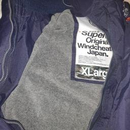 navy blue. Very warm. brand new with grey fleece lining. Still has wrapper on all the zips. has thumb hole in sleeves. Has SUPERDRY logo on shoulder and black. Size XL but since SUPERDRY runs slightly smaller than average UK size, this should fit men's large. Paid £120 for it only wanting £40 ono