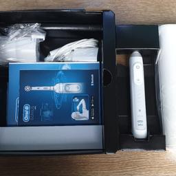 White electric toothbrush powered by Braun. Comes with UK 2 pin plug, smart travel case, phone holder, charging stand and 4 replacement toothbrush heads. Never used.