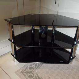 A GOOD QUALITY BLACK GLASS AND CHROME CORNER TV STAND IN VERY GOOD CONDITION, SIZES H-21 INCHES, D- 17.5 INCHES AND W- 31 INCHES AT WIDEST POINT.