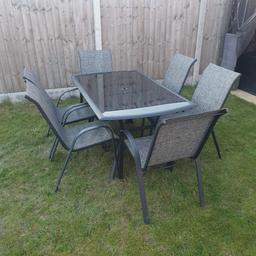 smoked glass table with 6 chairs, table has a few minor scratches and a couple of rubber feet have been lost from chairs not all of them. quick fix though. have got parasol base if wanted slightly rusted but very much use able £75 ono cost £200