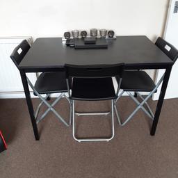black wooden table and 4 folding chairs from ikea.