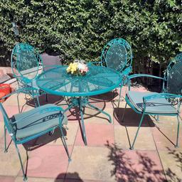 Great Condition
recently resprayed Green Gloss Finish- spare full can of touch up spray inc!! 
table surface
circumference 97cm
height 69cm
lovley patterned chairs with and arm rests and x4 matching soft cushion inserts with ties
parasol hold see pics -brolly not inc
sturdy metal
the odd slight scratch or rusting from outdoor sitting but overall great condition
please let me know if you would like to arrang a viewing.