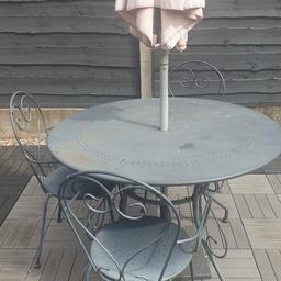 Metal table, 3 chairs and umbrella. Little bits rust but great quality and heavy.