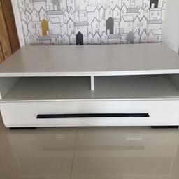 White melamine media unit with a high gloss drawer front and shiny black handle. 1 large drawer with metal runners. Cut out for cables. 37 cm h. 50 cm d. 100 cm w. Good condition. Cash on collection