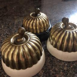 Old interesting brass and porcelain light switches 2 in white and 1 in black with brass screw on covers , great for interior design project.