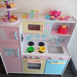 A well used and well loved play kitchen with lots of play left in it. 

The plastic sink (which is removable) has chips / marks but cosmetic only, doesn't effect the use.
Behind the sink there's a water stain running across the bottom of the splash back (see pic) where my daughter decided to wash up her play cups.

It's got a basket full of play food. The basket however is cracked so would need throwing away, I'm just using it to store all the food together. 
It's got an ELC singing teapot with