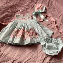 This beautiful Spanish designer boutique outfit includes a dress, bonnet and bloomers. Age 2-3. Brand new never worn. In mint and white with pink. Absolutely stunning set. Romani style.