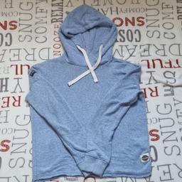 SuperDry hoodie in pale blue colour with white speckles. Size XS on label. Soft material on the outside and terry material on the inside. High funnel style neck. 2 sewn on superdry badges. One on right shoulder the other on the near left hem. Raw hem. Worn but its still on good condition.