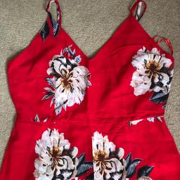 Red with floral design. Brand mela loves London. Size uk 14 but can fit uk 10-14 as has adjustable straps