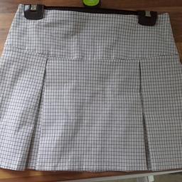 Checked short skirt. Never worn. From topshop size 10. Has pleats down the front. Zip to fasten. Colours of the check are on the laat picture.