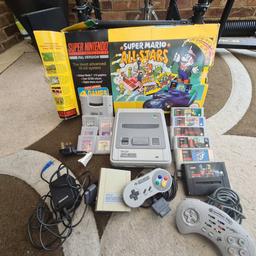 Great condition SNES console in box.
Gameboy game adapter. 
1 original controller + 1 branded controller. 
SNES Games include - Super Mario World, Killer Instinct, Cliffhanger, Super Soccer, F Zero and Scope 6.
Gameboy games to play through adapter include -
Dr Mario, Mario and Yoshee, Star Saver, Tetris, Addams Family and Monster Match.
Audio/visual lead missing. These are on ebay for £3. Alternatively, it's the same cable as game cube and n64.

Collection preferred.