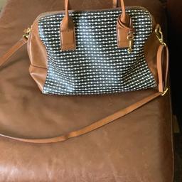 Here is my fossil bag in used condition with some small marks on the corners and some use inside. It has twin handles and a removable adjustable crossbody strap. Inside are two slip pockets and an open one. It has the fossil key charm