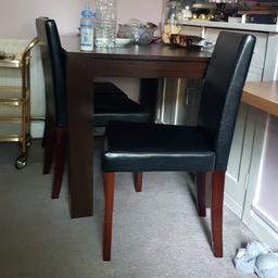 in fair condition wooden dining table with 3 Pvc leather look alike chairs.