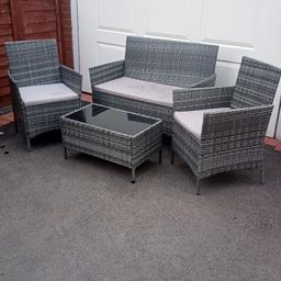 4 piece set of rattan garden furniture
grey with pale grey waterproof cushion pads 2 armchairs 1 sofa and a black glass topped low table