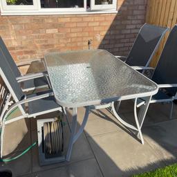 Four reclining chairs and glass top table