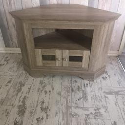 Corner TV cabinet in rustic washed wood effect. Fits TV up to 40". Has 2 x glass front doors. H63 W95 D 50cm.
In excellent condition