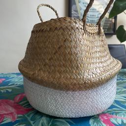 Wicker basket, round, with white bottom and handles.