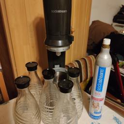 Einen Sodastream Wassersprudler mit 5 Glasflaschen und einem leeren Gaszylinder.