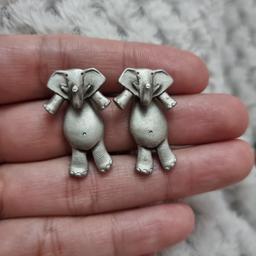sweet pewter earrings by Mali in the shape of elephants. the head is the front and body is the back of the earrings.
