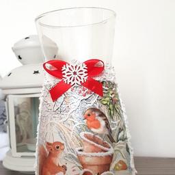 Height: 20 Centimetres; Width: 11 Centimetres

Absolutely stunning glass vase with winter animals design. Beautiful white vase with robin and squirrel I the center of this vase.
Finished paste imitiating snow.
On the top wooden white snowflake with red satin ribbon.

Handcrafted, painted and decoupage glass vase or carafe.

Perfect gift for someone you love.