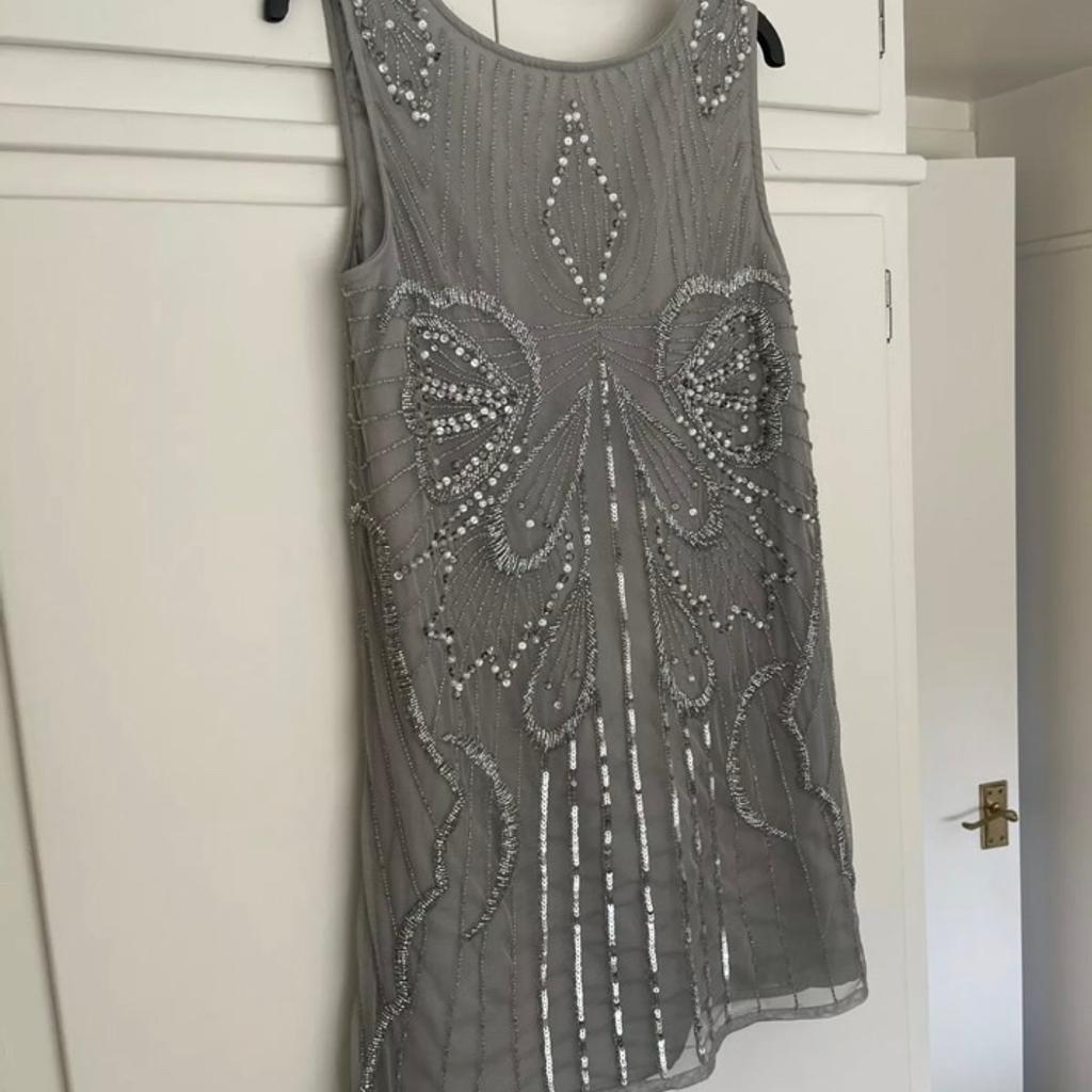 River Island Grey Vest Top Blouse With Sequins And Inner Lining. UK Size 6. Item has a low back.

Item is very heavy and just absolutely beautiful.

Condition is "Used”. Item has been worn on a couple of occasions but still in great condition. From a pet and smoke free home. Item bought as seen - thanks for looking.