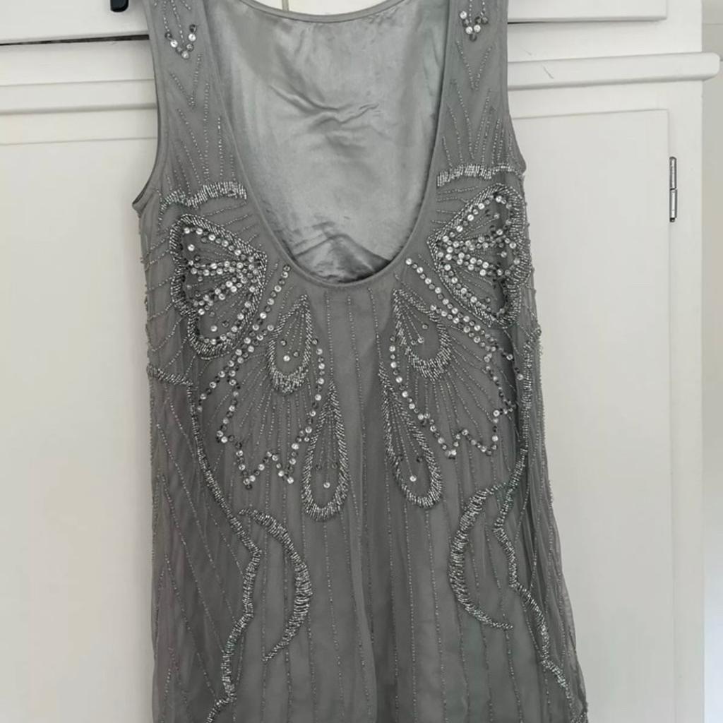 River Island Grey Vest Top Blouse With Sequins And Inner Lining. UK Size 6. Item has a low back.

Item is very heavy and just absolutely beautiful.

Condition is "Used”. Item has been worn on a couple of occasions but still in great condition. From a pet and smoke free home. Item bought as seen - thanks for looking.