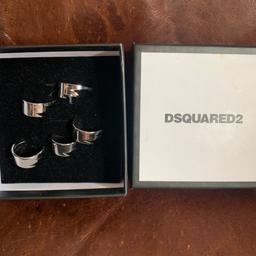 You are buying a set of stunning dsquared2 rings.


There are 5 of these rings that can be worn on one hand or spread across both , the rings are slightly malleable so you can bend them to fit any fingers


These are brand new and come in the original box


Please check my other sales for some more designer pieces