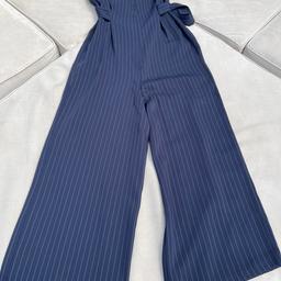 Top shop size 8 navy blue jumpsuit with pinstripe in cream/white. Darted bust to give fitted effect and waist band detail. Flowing wide leg in moving light fabric making this suitable for all seasons.