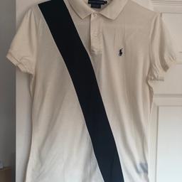 Ralph Lauren Polo Shirt size L.
Ivory with Navy diagonal stripe down front. Two button up. Navy stitched Horse logo on left breast. Longer length at back with slit side vents.