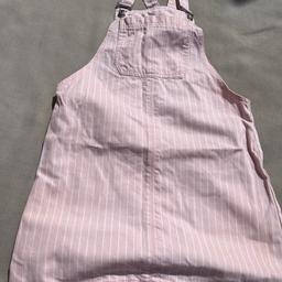 Pale pink with white pinstripe denim mini dungarees. Denim button dungaree straps and front pocket.