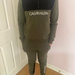 CK Khaki green older boys tracksuit . Barely worn . No rips , no bobbles . Hood and pockets in both the hoodie and bottomed  . Smoke free home