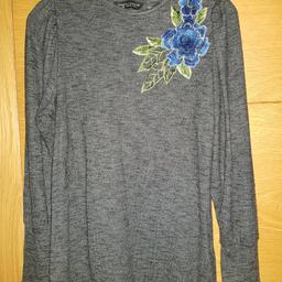 Ladies dark grey long sleeved round neck jersey top with blue flower embellishment on shoulder from Dorothy Perkins. Size 12. 65% viscose/31% polyester/4% elastane and machine washable. In beautiful, good as new condition. As well as free collection from us, we also offer UK postal delivery for £3.19.