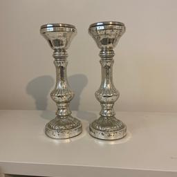 Set of 2 silver coloured candlesticks in superb condition will hold a large pillar candle 
Collection from ware
