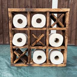 Wooden handmade naught’s & crosses toilet roll storage shelf has space for 6 toilet roll’s comes with 3 movable crosses fun idea for storing your toilet rolls this has been made to sit free standing on floor or cabinet But could be provided with hangers so could be fixed to wall , measurements are 43 cmx43cm x 10cm