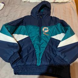 Mens Pro Player NFL Miami Dolphins Puffer coat Size Medium Vintage 90s.

In Good condition,No marks no scratch,
immaculate condition (See photos) for more details 
Embroidered logos, two front pockets and hooded. Very thick and warm.

Pit to pit 24”

Length 27”