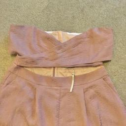 Wide leg cut out J/suit, off the shoulders with invisible back zip on the trousers but on the top small visible zip. Front pleats with side pockets cross over bra top. Rusty pink colour
