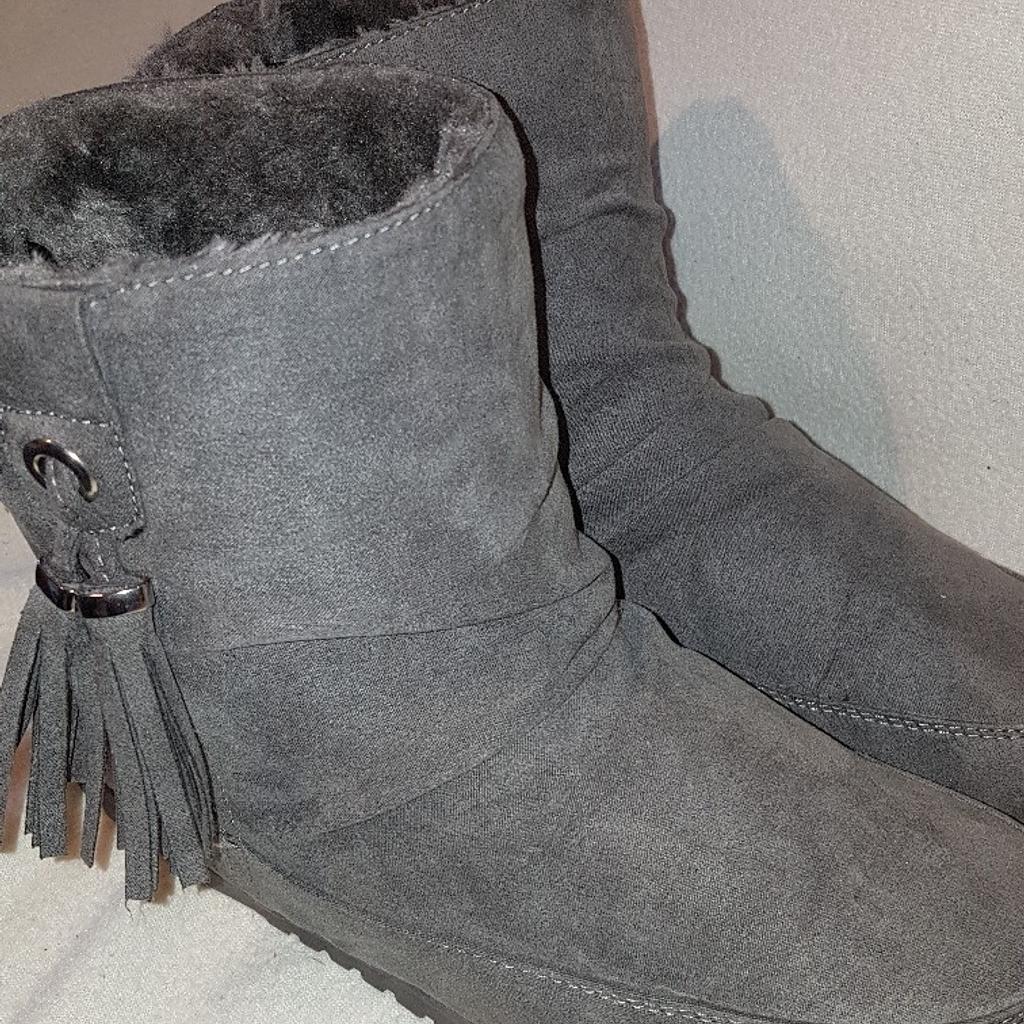 Grey Faux Fur Lined Ugg style Snow Boots with tassels Barely worn condition uk5. See photos for condition and size. I can offer try before you buy option but if viewing on an auction site viewing STRICTLY prior to end of auction.  If you bid and win it's yours. Cash on collection or post at extra cost which is £4.55 Royal Mail 2nd class signed for. I can offer free local delivery within five miles of my postcode which is LS104NF. Listed on five other sites so it may end abruptly. Don't be disappointed. Any questions please ask and I will answer asap.