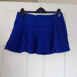 Topshop short pleated skirt
Size 12
Button details at the front
Fastens at the back with a zip