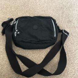 Hardly used Kipling crossbody bag with Lesley monkey attachment. The front pocket unzips all the way to reveal a mobile phone pocket, 2 x pen slots & another small slot for hand size tissues. The bag of the bag has more storage bag which has a Velcro fastening. The main part of the bag has a zip top fastening, & the inside contains a zipped back pocket & a key fob
Colour: black
Bag height: 10 ins 
Bag width: 10 ins
Bag depth: 3 ins 
Strap length extends to 57.50 ins
Hardly been used so still in excellent condition