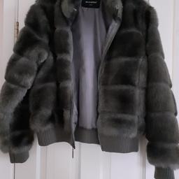Atmosphere faux fur jacket, more like size 14.  In the sunlight looks greyish, has elasticated knitted cuffs and at the bottom of the jacket. Small tear at bottom. of zip.