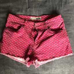 Stonewashed red shorts with white heart print and frayed hems, size 26” waist, by Topshop.
Great condition as only worn a few times.