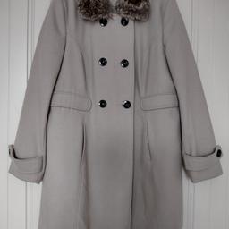This is a very good quality wool blend coat. New with the spare button attached. Size 18, double breasted and fully lined. Soft camel colour. It has pockets and a detachable faux fur collar. Length including collar 36 1/2".

Collection from Plumstead London SE18.