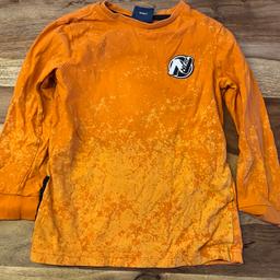 Dieser orangene Pullover hat das farblich abgesetzte Nerf Logo und enthält einen kleinen handlichen Nerf Kugelhalter, der perfekt für die Aufbewahrung heimlicher Kugeln ist.